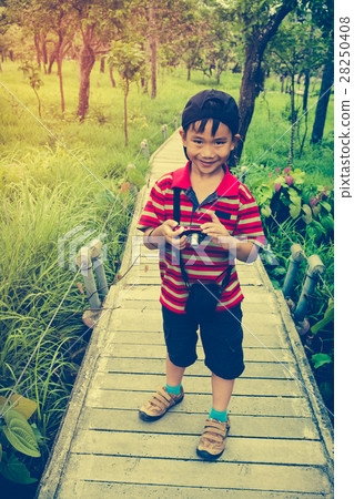 Happy asian boy relaxing outdoors in the day time Happy asian boy relaxing outdoors in the day time 28250408