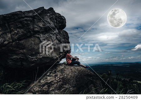 Woman sit on boulders, sky with cloudy and moon Woman sit on boulders, sky with cloudy and moon 28250409