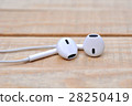 White headphones on wooden table 28250419