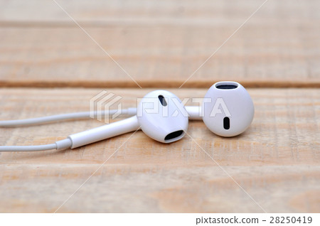 White headphones on wooden table White headphones on wooden table 28250419