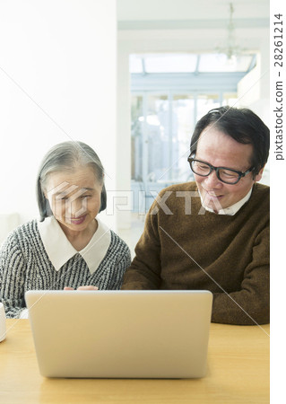 一對60多歲的夫婦在起居室裡使用個人電腦 28261214