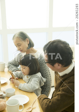 A family surrounding the table 28261283
