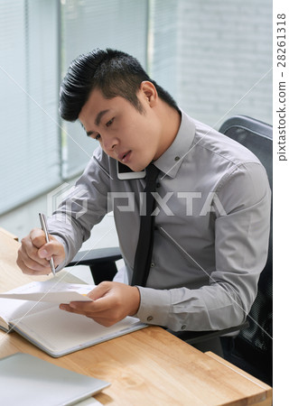 Young businessman wrapped up in work 28261318