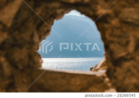 Stone window overlooking landscape Garda lake 28266545
