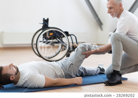 Charismatic orthopedist stretching the handicapped 28269202