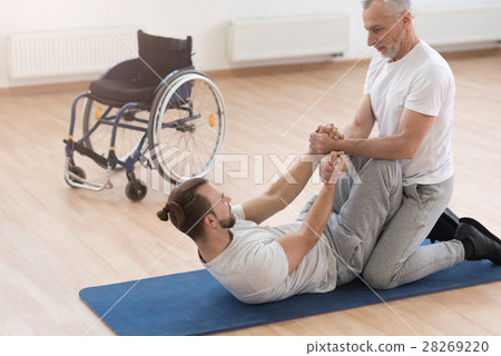 Strong aged orthopedist assisting the disabled in 28269220