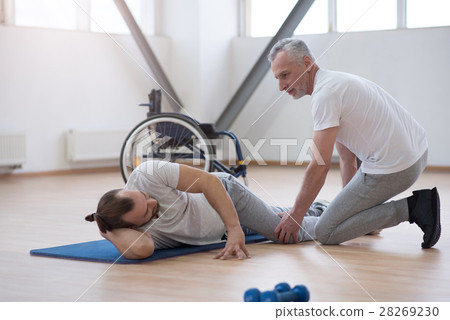 Mindful physical therapist stretching the disabled Mindful physical therapist stretching the disabled 28269230