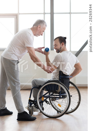 Confident disabled man exercising with his coach Confident disabled man exercising with his coach 28269344