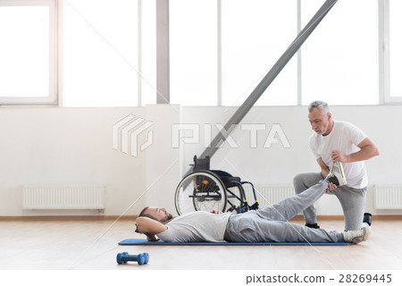 Skilled orthopedist working out with disabled 28269445
