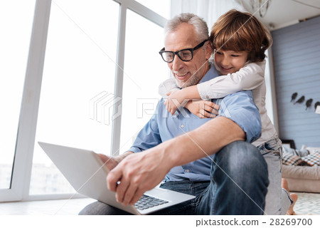 Handsome cheerful man holding a laptop Handsome cheerful man holding a laptop 28269700