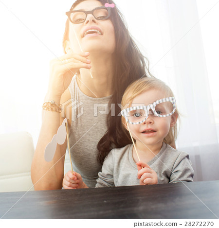 Mother and her daughter with a paper accessories. Mother and her daughter with a paper accessories. 28272270