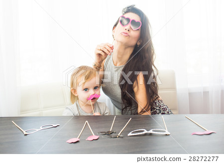 Mother and her daughter with a paper accessories. Mother and her daughter with a paper accessories. 28272277