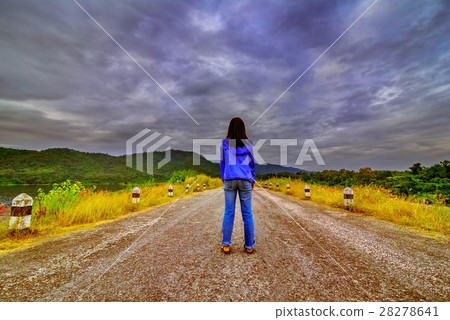 Beautiful girl standing on the rural road Beautiful girl standing on the rural road 28278641