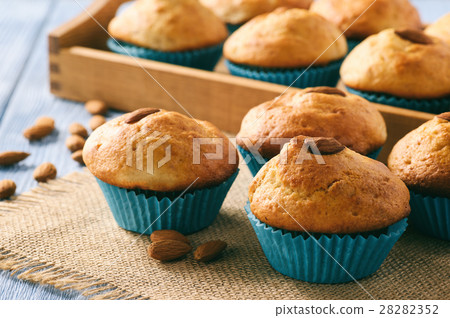 Sweet muffins with almond on blue wooden table. 28282352