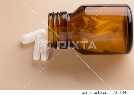 Brown glass pill bottle and white pills Brown glass pill bottle and white pills 28284491