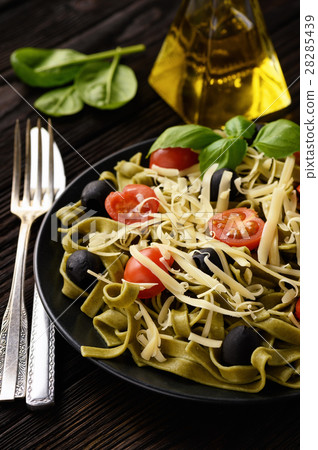 Spinach green pasta with olives, tomatoes, cheese Spinach green pasta with olives, tomatoes, cheese 28285439