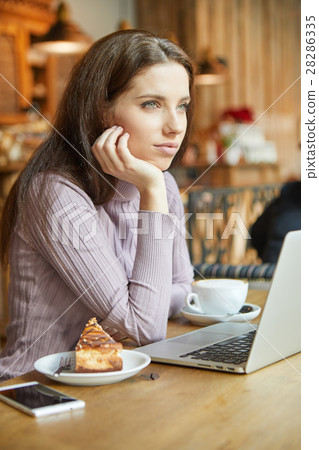 Beautiful brunette using laptop in cafe. Blogger work concept 28286335