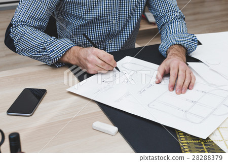 Male designer sitting at desk and drawing 28288379