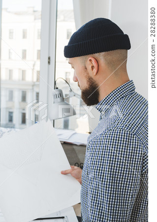Young modern businessman holding plan, side view Young modern businessman holding plan, side view 28288380