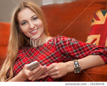 Portrait of happy woman with mobile phone sitting Portrait of happy woman with mobile phone sitting 28288436
