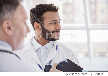 Smiling physician telling with doctor in hospital Smiling physician telling with doctor in hospital 28290445