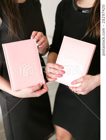 Two girls hold business notebooks in hand 28297420
