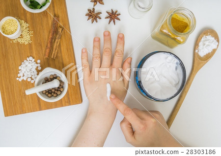Woman is applying home made cream on hand. 28303186