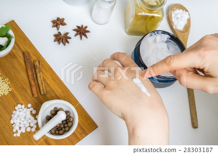 Young woman is applying homemade cream on her skin 28303187