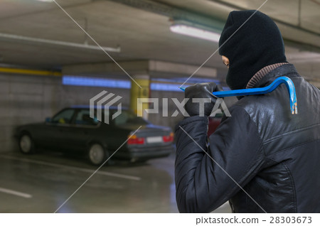 Thief with crowbar is going to steal car Thief with crowbar is going to steal car 28303673