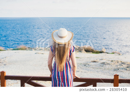 Back view of woman standing in summer dress and 28305410