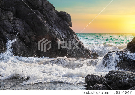 Sea waves and splashes breaking on rocks in sunset Sea waves and splashes breaking on rocks in sunset 28305847