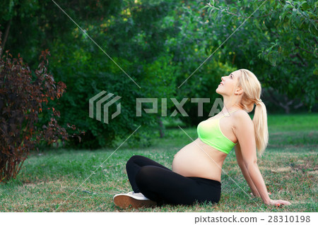 Pregnant woman having sunbath outdoor, free space Pregnant woman having sunbath outdoor, free space 28310198