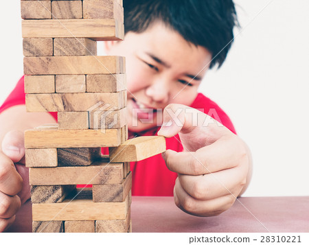 Asian kid is playing wood blocks tower game Asian kid is playing wood blocks tower game 28310221