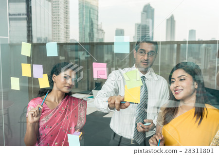 Indian employees sticking reminders on glass wall  28311801