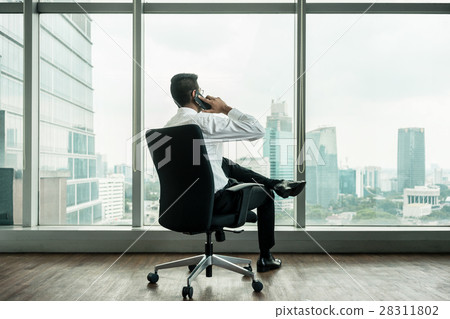 Rear view of businessman talking on phone  28311802