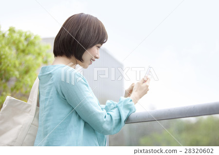 A woman operating a smartphone 28320602