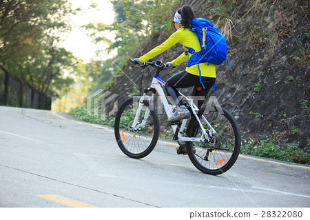 woman cyclist riding mountain bike on forest trail woman cyclist riding mountain bike on forest trail 28322080