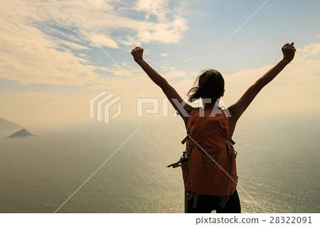 cheering young woman hike at seaside mountain peak 28322091