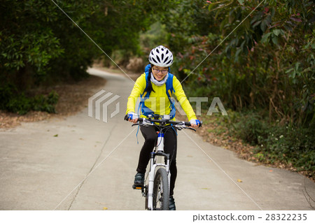young woman riding mountain bike on forest trail 28322235