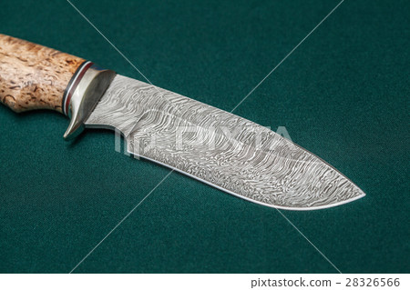 Hunting damascus steel knife on a green fabric 28326566