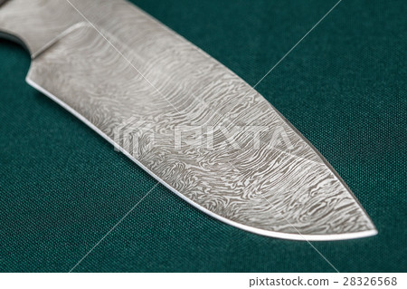Hunting damascus steel knife on a green fabric 28326568