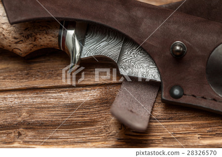 Hunting damascus steel knife on wooden background 28326570