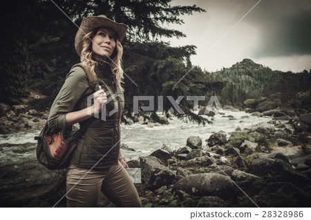 Beautiful woman hiker near wild mountain river. 28328986