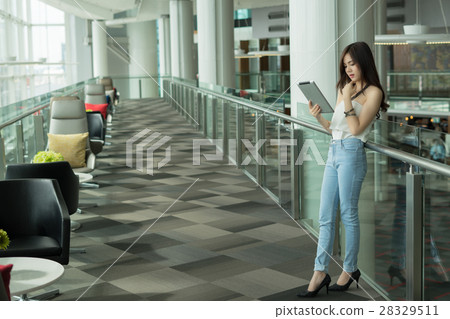 Beautiful Young Asian women reading tablet Beautiful Young Asian women reading tablet 28329511