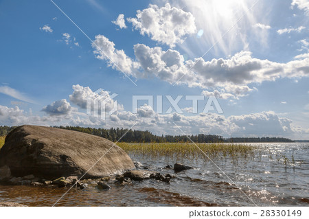 Lake with a large stone on a sunny day. Lake with a large stone on a sunny day. 28330149