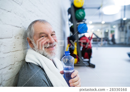 Fit senior man in gym resting after working out. Fit senior man in gym resting after working out. 28330168