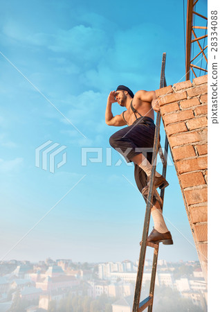 Builder leaning on brick wall and sitting on Builder leaning on brick wall and sitting on 28334088
