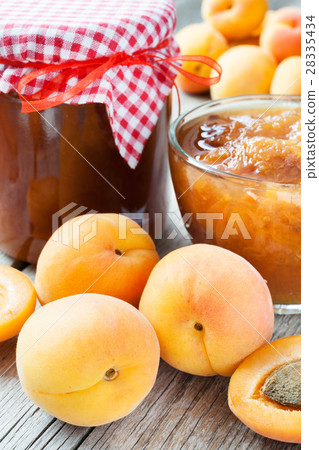 ripe apricot fruits and jar of jam on table ripe apricot fruits and jar of jam on table 28335434