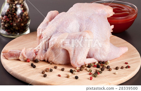 raw chicken carcass with peppercorns on a dark raw chicken carcass with peppercorns on a dark 28339500
