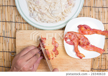 Chef cutting bacon with knife Chef cutting bacon with knife 28340610